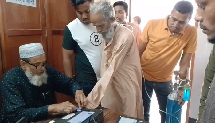 অক্সিজেন সিলিন্ডার নিয়ে ভোটকেন্দ্রে ৮০ বছরের বাকের আলী