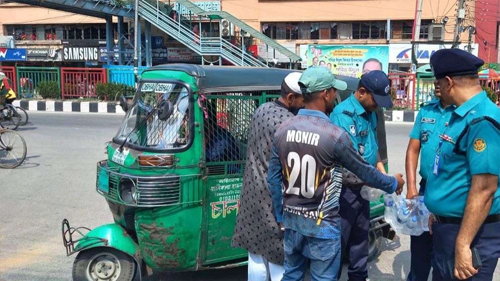 তৃষ্ণার্ত মানুষের খাবারের পানি সরবরাহ করছেন পুলিশ