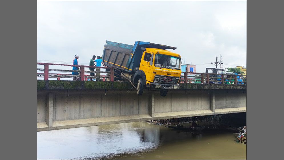 সেতুর রেলিং ভেঙে ঝুলে আছে ট্রাক